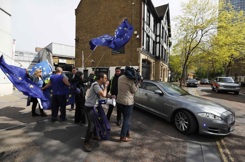 © Reuters. Pro-European Union demonstrators wave flags as Britain's Prime Minister Theresa May leaves ITV's studios, in London