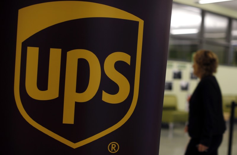 © Reuters. FILE PHOTO: Woman walks past a sign bearing the UPS logo at a job fair in Chicago
