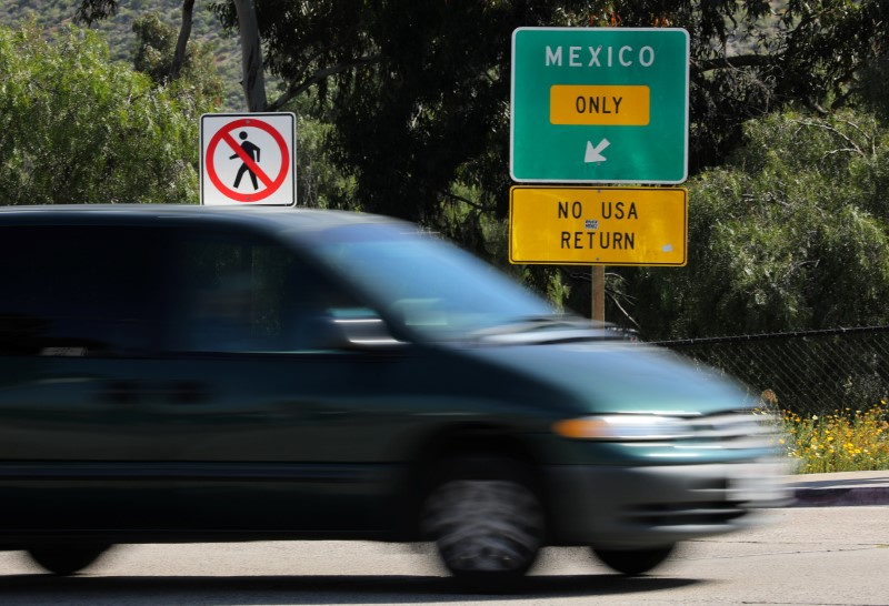 © Reuters. A vehicle travels past an exit sign directing traffic to the Mexican border crossing in San Ysidro, California