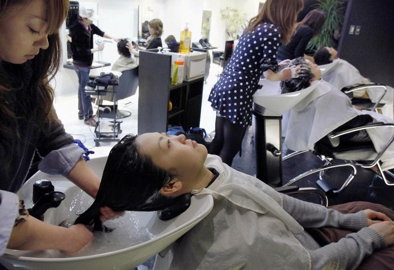 © Reuters. A woman receives a 12 dollars (1000 yen)  hair washing service at a hair salon  in Sendai City, Miyagi Prefecture