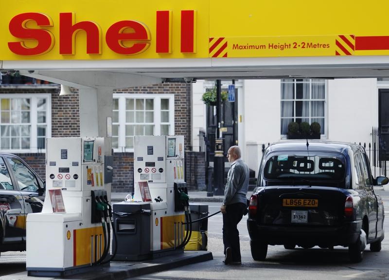 © Reuters. A driver fills up with fuel at a Shell petrol station in London