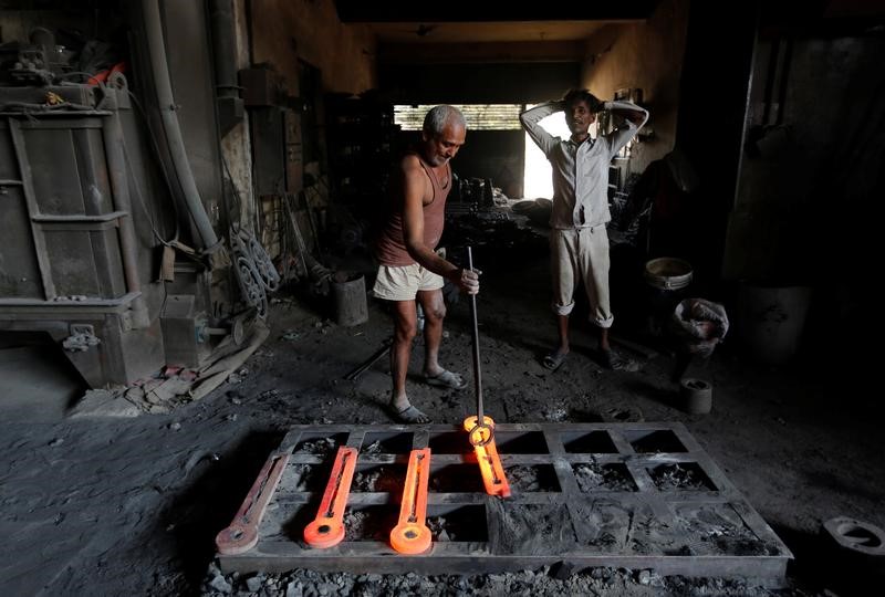 © Reuters. A worker makes parts for lamp posts inside an iron casting factory in Ahmedabad
