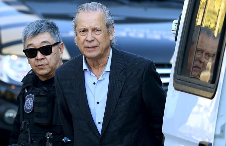 © Reuters. José Dirceu, ex-ministro da Casa Civil do governo Lula, é levado por agente da Polícia Federal para depor em sessão de Comissão Parlamentar de Inquérito em Curitiba, no Paraná