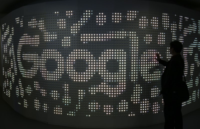 © Reuters. An attendee interacts with an illuminated panel at Google stand during the Mobile World Congress in Barcelona