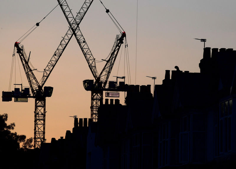 © Reuters. FILE PHOTO: Construction cranes are seen on a residential building project behind homes in London
