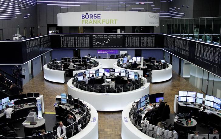 © Reuters. Traders work at their desks in front of the German share price index DAX board in Frankfurt