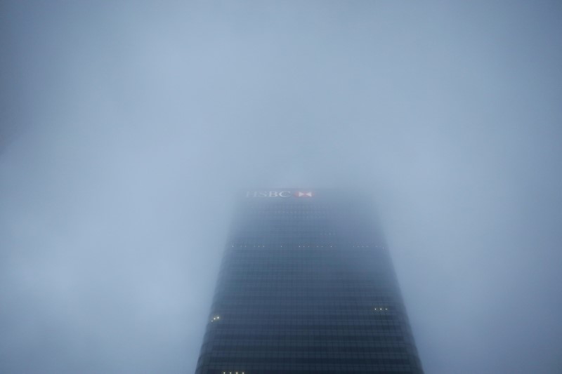 © Reuters. FILE PHOTO: The logo on the building of HSBC's London headquarters appears through the early morning mist in London's Canary Wharf financial district