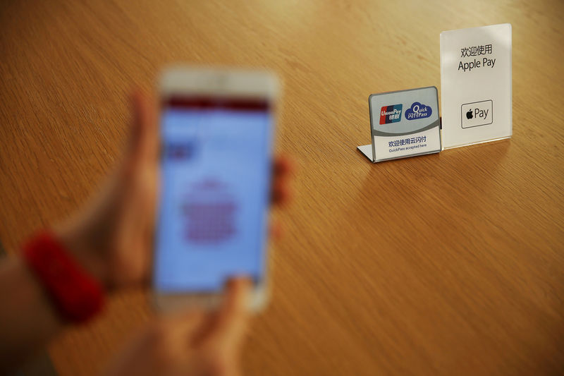 © Reuters. FILE PHOTO: An employee uses the Apple iPhone to demonstrate to reporters how to pay using the Apple Pay service in Beijing