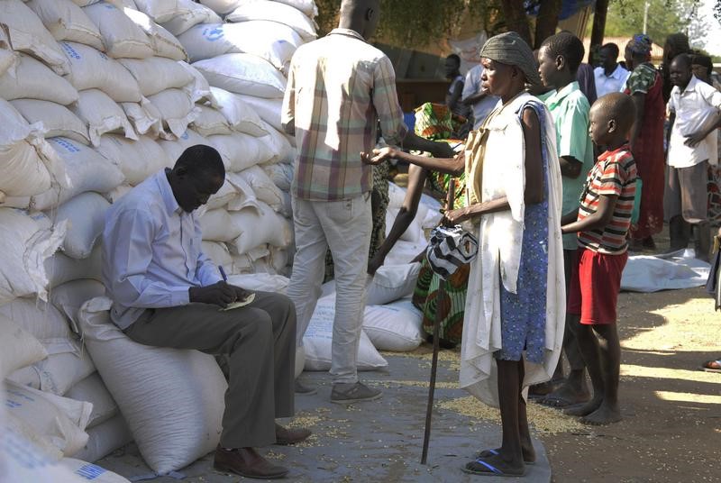 © Reuters. An internally displaced South Sudanese woman (R) waits to receive food aid from the World Food Programme in Bor, Jonglei state