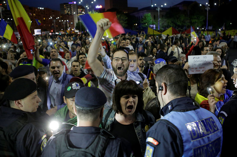 © Reuters. Protesters shout slogans during a demonstration in front of the government building in Bucharest,