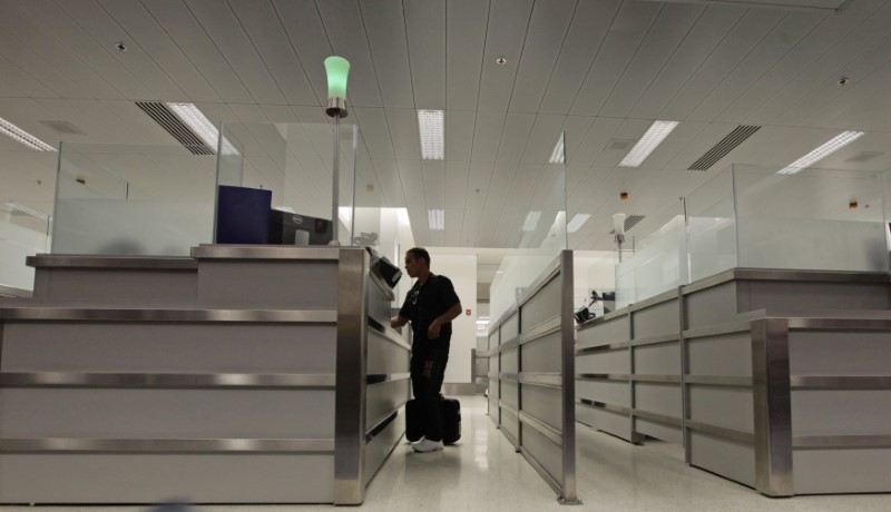 © Reuters. A person stands at the counter of U.S. Immigration upon arriving at Miami airport March 13, 2013.