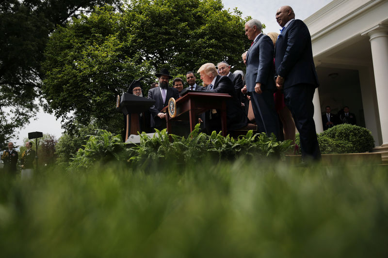 © Reuters. U.S. President Donald Trump signs an Executive Order on Promoting Free Speech and Religious Liberty during the National Day of Prayer event at the Rose Garden of the White House in Washington D.C.