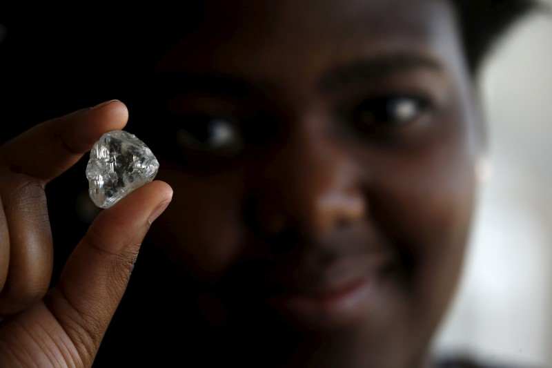 © Reuters. A visitor holds a diamond during a visit to the De Beers Global Sightholder Sales (GSS) in the capital Gaborone