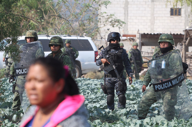 © Reuters. Military personnel keep watch as residents protest against the army after an incident with suspected oil thieves in the community of El Palmarito