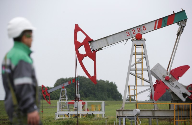 © Reuters. Worker looks at pump jack at oil field Buzovyazovskoye owned by Bashneft company north from Ufa