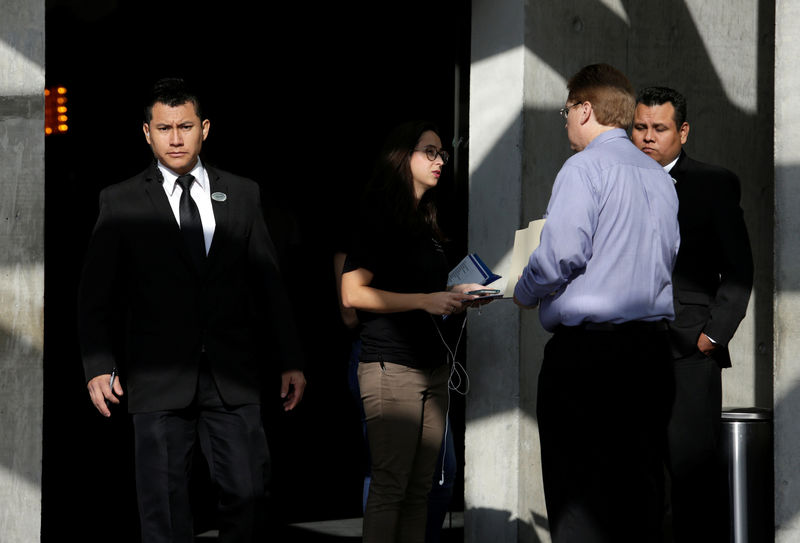 © Reuters. Security employee looks on as a recruiter from Tesla talks to a job seeker at the hotel where the electric vehicle maker is holding a recruiting event for its California factory, in the municipality of San Pedro Garza