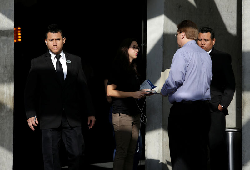 © Reuters. Un funcionario de seguridad mira mientras un reclutador de Tesla habla con un postulante a un empleo en un hotel cerca de Monterrey