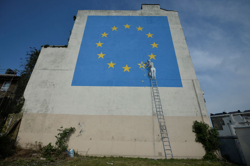 © Reuters. Una obra de arte atribuida al artista callejero Banksy, que representa a un trabajador quitando una de las 12 estrellas en la bandera de la Unión Europea, es vista en una pared en el puerto de ferries de Dover