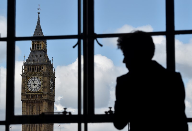 © Reuters. A woman looks out of a window at the Big Ben clock tower in London