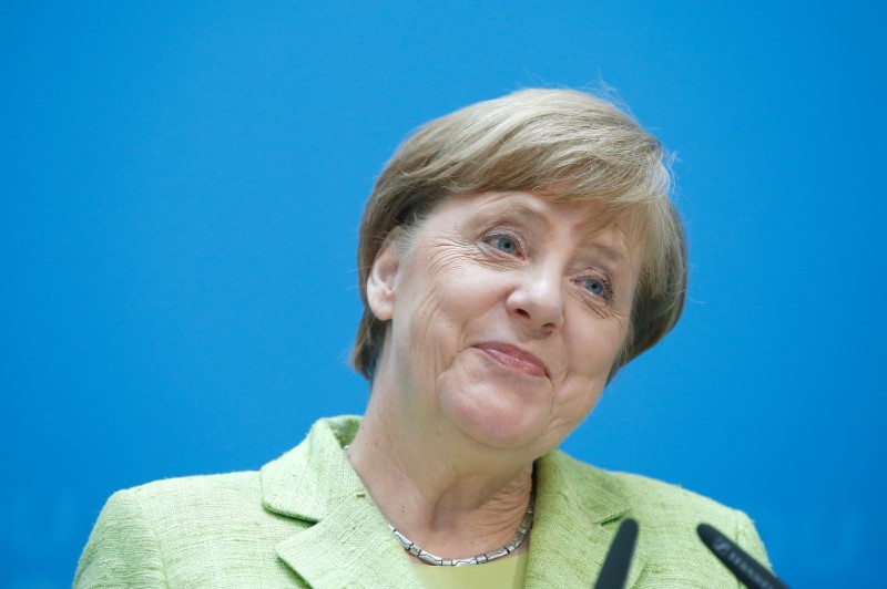Praising Macron, Merkel says Germany's hands tied on trade surplus