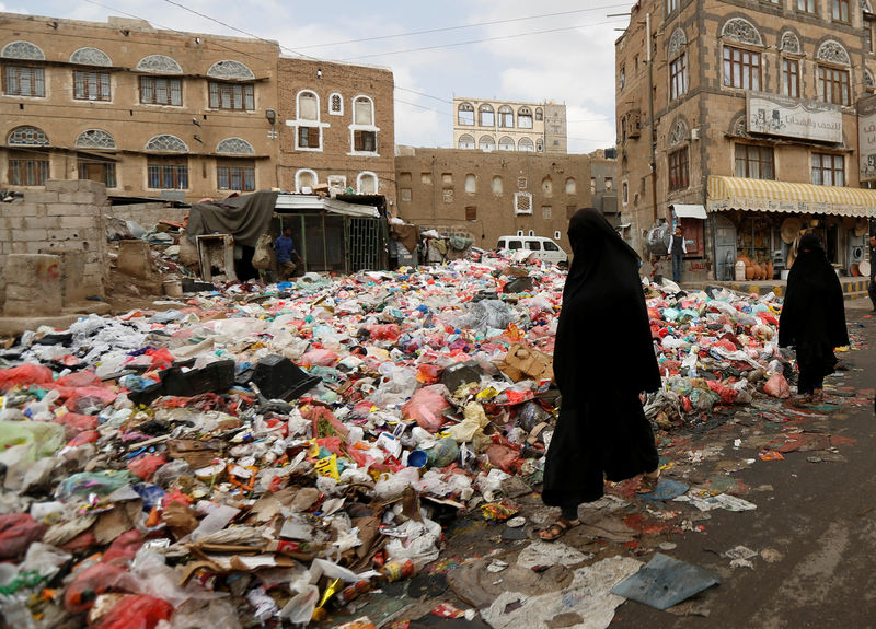 © Reuters. Women walk past a pile of rubbish bags on a street during a strike by garbage collectors demanding delayed salaries in Sanaa, Yemen