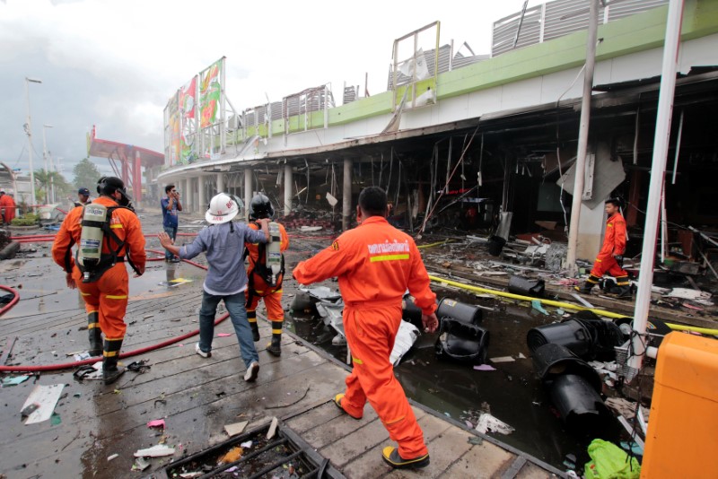 © Reuters. Rescue workers are seen at a blast site outside a supermarket in Pattani