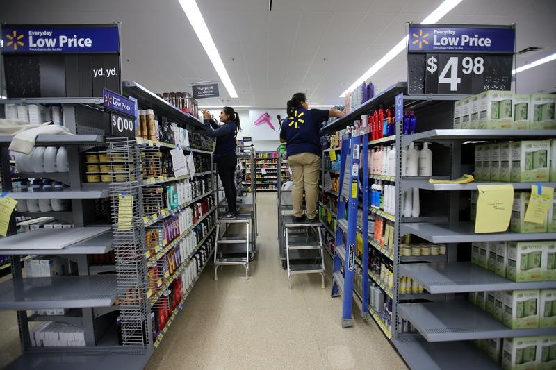 © Reuters. Workers stock shelves in a newly built Walmart Super Center prior to its opening in Compton, California