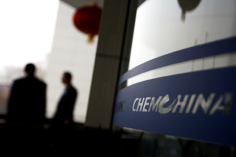 © Reuters. FILE PHOTO: People smoke outside the headquarters of the China National Chemical Corp, or ChemChina, in Beijing