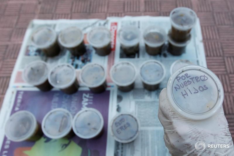 © Reuters. Manifestantes venezolanos preparan cócteles de excrementos para lanzar a fuerzas de seguridad