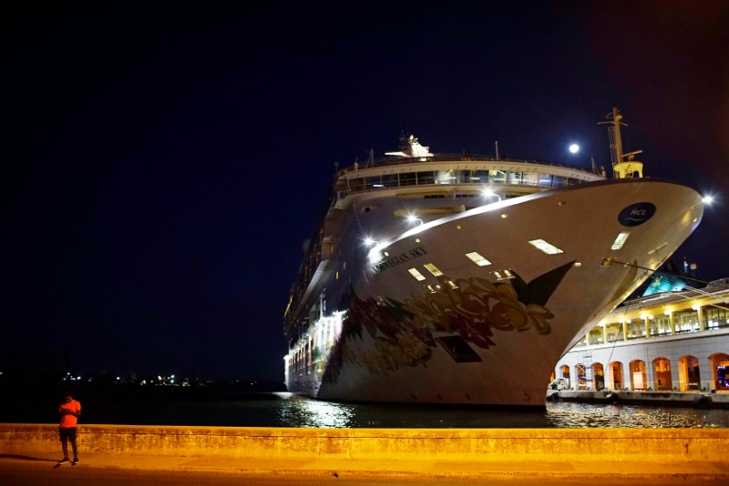 © Reuters. A man uses his mobile phone near the cruise ship Norwegian Sky in Havana