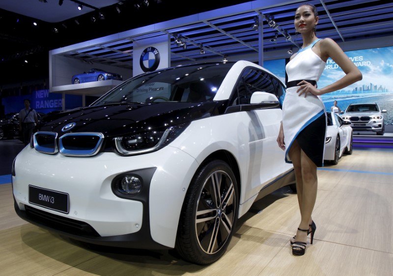 © Reuters. FILE PHOTO: A model poses beside a BMW i3 during a media presentation during the 36th Bangkok International Motor Show in Bangkok