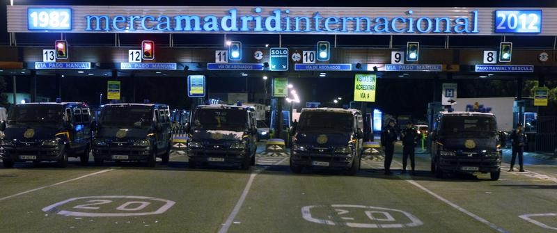 © Reuters. Riot police officers stand guard outside Madrid's main food warehouse "MercaMadrid" at the start of a general strike in Spain