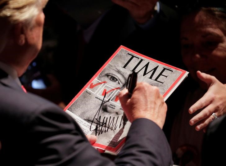 © Reuters. Candidate Donald Trump signs a magazine with his picture on it at a campaign rally in Raleigh, North Carolina, July 2016.      REUTERS/Joshua Roberts
