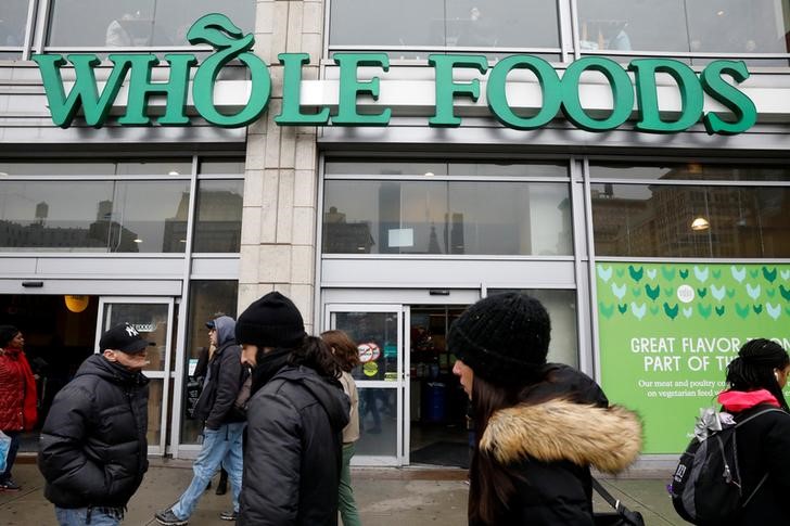 © Reuters. People pass by a Whole Foods Market in New York