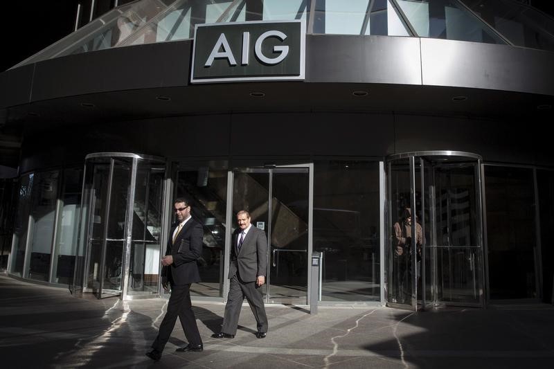 © Reuters. People exit the AIG building in New York's financial district