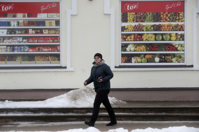 © Reuters. A woman leaves a local shop about 5 km (3,1 miles) from the border with Russia in Karsava