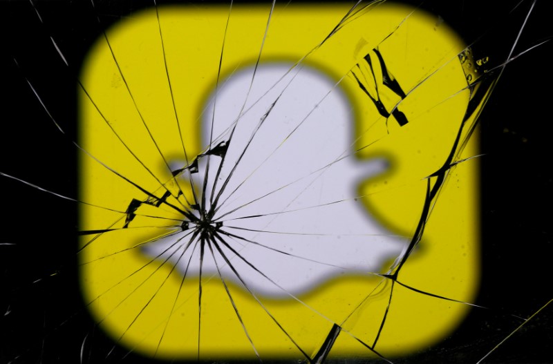 © Reuters. Snapchat logo is seen through broken glass in this illustration