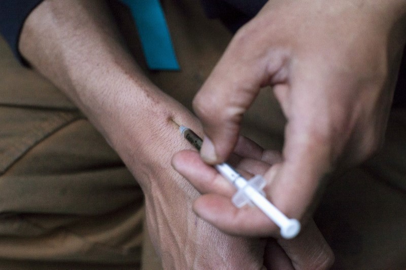 © Reuters. FILE PHOTO - A man injects himself with heroin using a needle obtained from the People's Harm Reduction Alliance, the nation's largest needle-exchange program, in Seattle