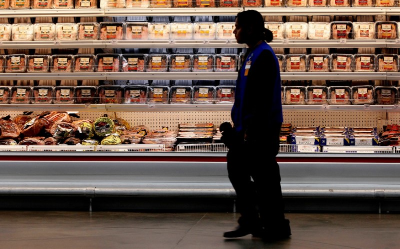 © Reuters. FILE PHOTO - A employee walks by a meat cooler in the grocery section of a Sam's Club in Bentonville