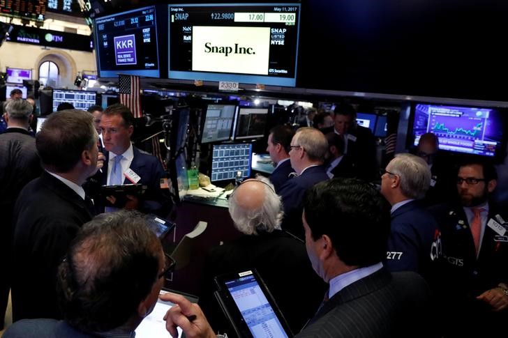 © Reuters. Traders gather at the post where Snap Inc.. is traded, just before the opening bell on the floor of the NYSE in New York