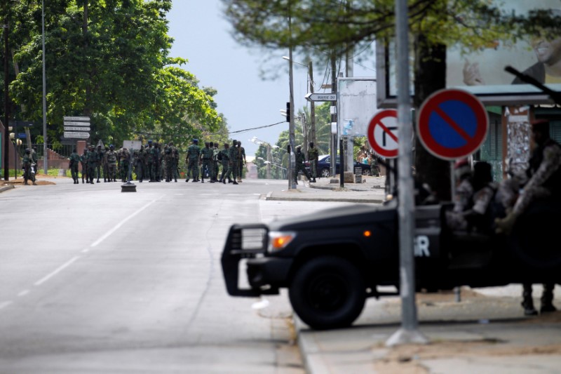 © Reuters. Mutinying soldiers stand next to their camp as they protest over a pay dispute in the centre of the commercial capital Abidjan