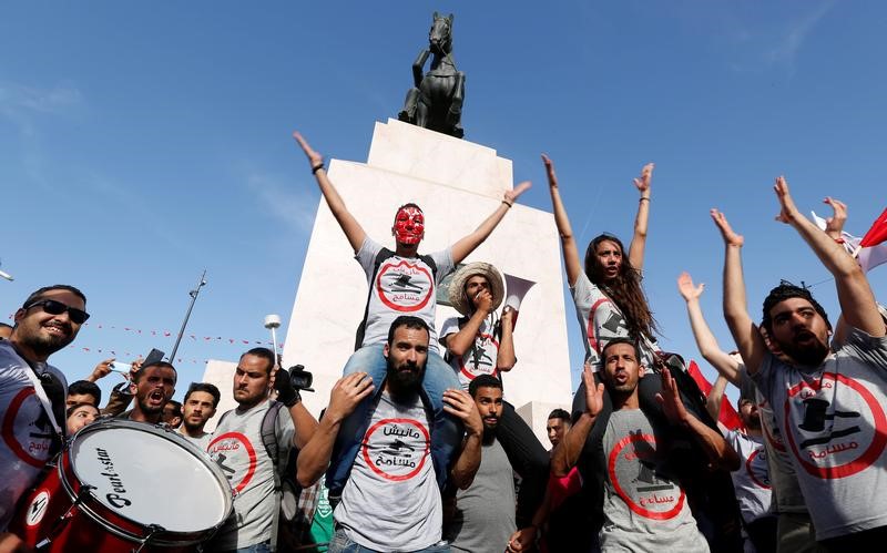 © Reuters. تونسيون يحتجون على قانون للمصالحة مع رجال أعمال من نظام بن علي