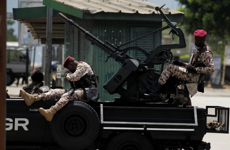 © Reuters. Soldados de la guardia presidencial de Costa de Marfil toman posiciones frente a un motín en el centro de la capital comercial, Abiyán.