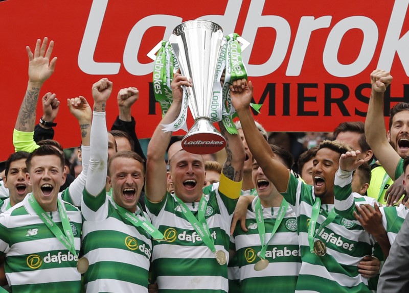 © Reuters. Celtic's Scott Brown celebrates with the trophy after winning the Scottish Premiership