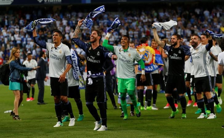 © Reuters. Foto del domingo de los defensores del Real Madrid Sergio Ramos y Raphael Varane celebrando el título de la liga española de fútbol