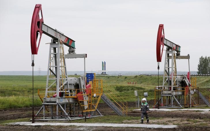 © Reuters. Pump jacks pump oil at oil field Buzovyazovskoye owned by Bashneft company north from Ufa