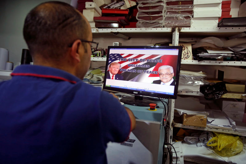 © Reuters. Palestinian man prints posters depicting U.S. President Trump in preparations for his planned visit, in the West Bank town of Bethlehem