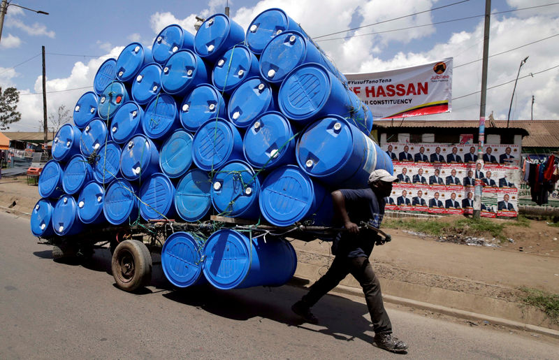 © Reuters. FILE PHOTO: A porter transports a cart loaded with empty plastic drums to a recycling dealer in the outskirts of Kenya's capital of Nairobi