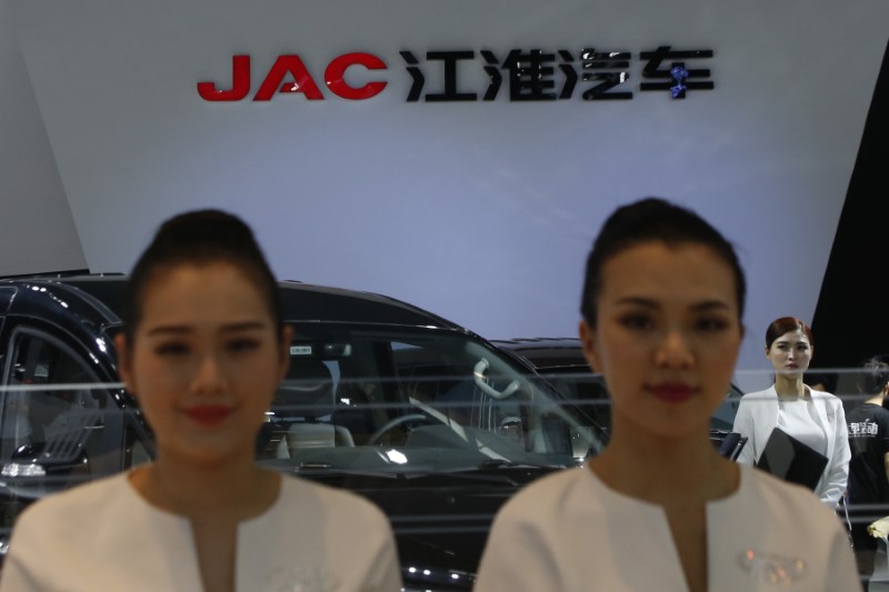 © Reuters. Hostesses stand in front of the logo of Anhui Jianghuai Automobile Co (JAC Motors) at its booth during the Auto China 2016 auto show in Beijing
