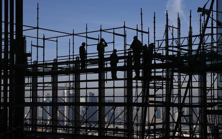 © Reuters. Construction workers are silhouetted while standing on scaffolding at the construction site of the new  ECB headquarters during a guided media tour in Frankfurt